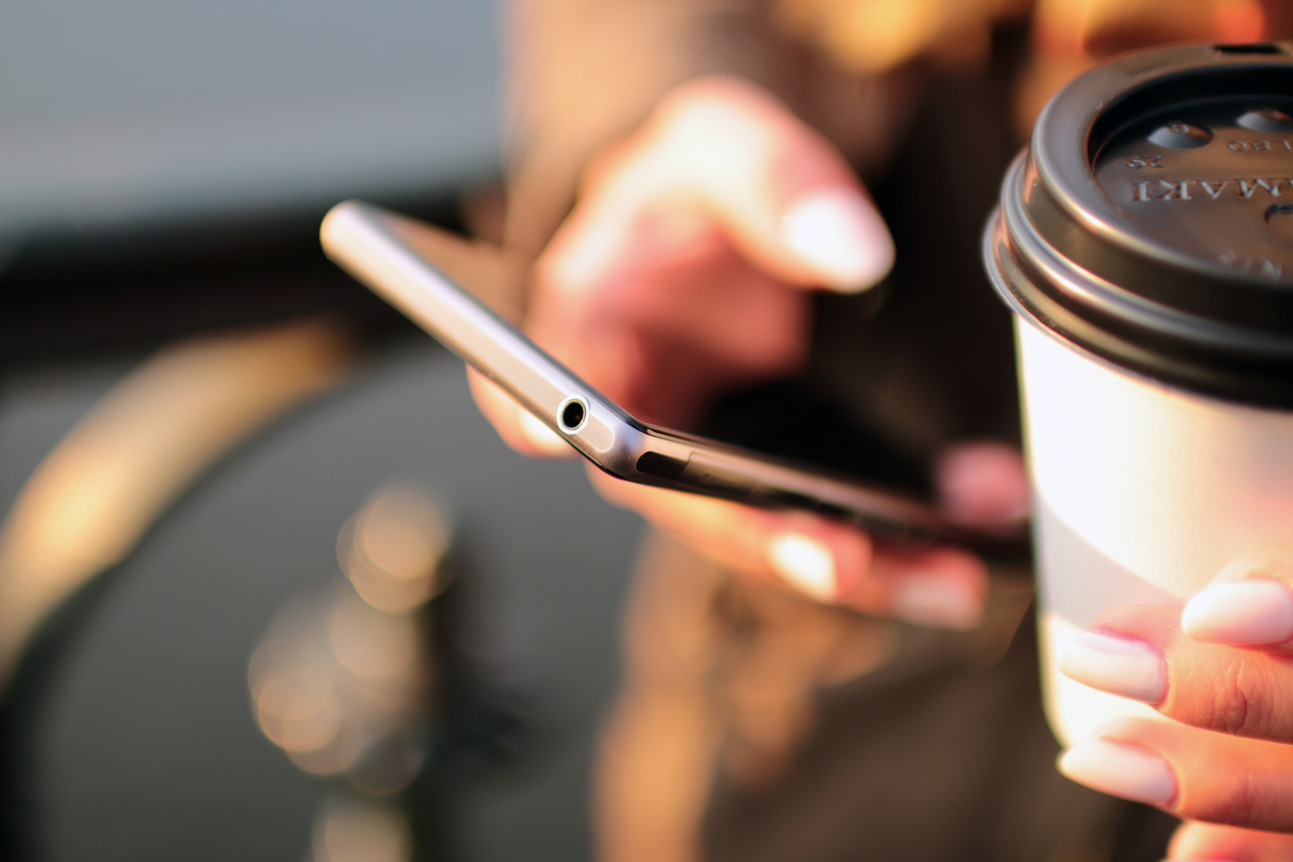 person-holding-coffee-and-phone